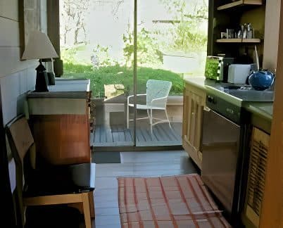 Kitchen and dining area with view to patio and garden through glass doors