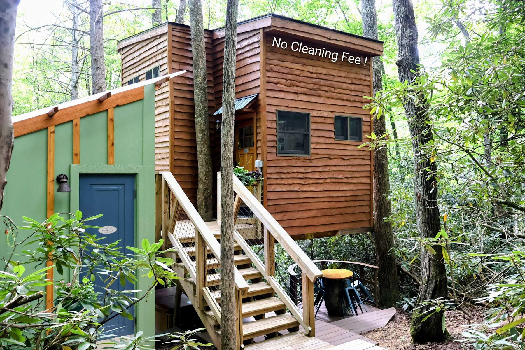 Wooden treehouse structures nestled among forest trees with green and brown siding