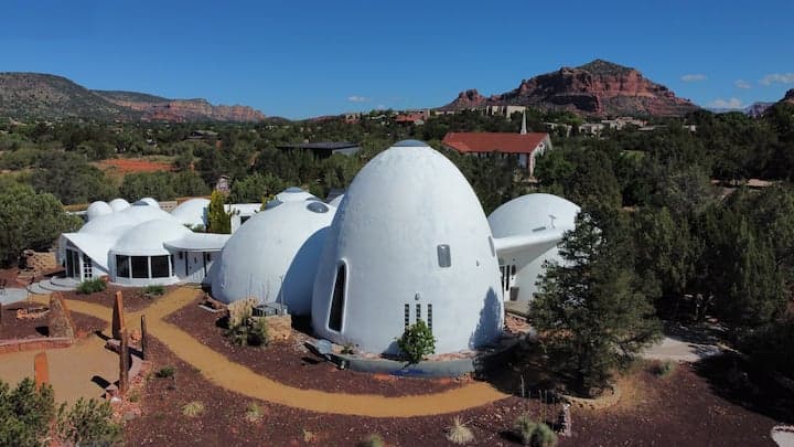 Distinctive white dome structures set against red rock formations and desert landscape