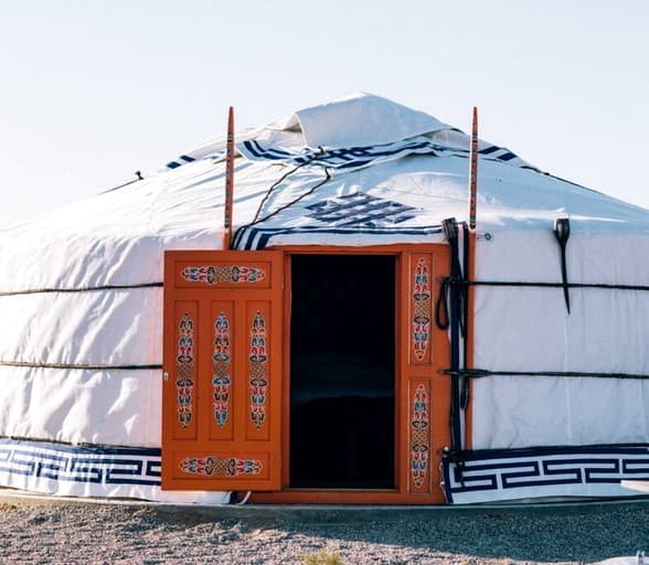 Yurt entrance with ornate wooden door and traditional Mongolian design