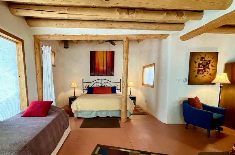 Spacious bedroom with exposed wood beams, canopy bed, and Southwestern decor
