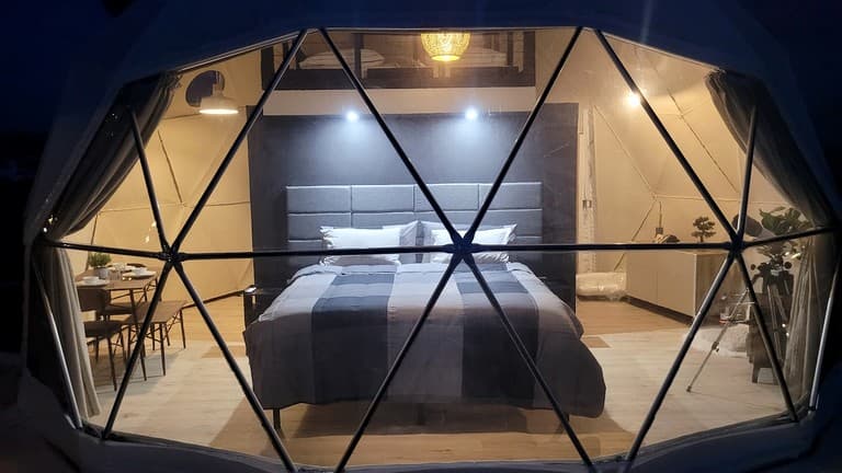 Interior of geodesic dome with queen bed and modern furnishings