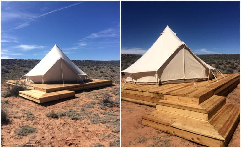 Two cream-colored bell tents on wooden decks in high desert under clear blue sky
